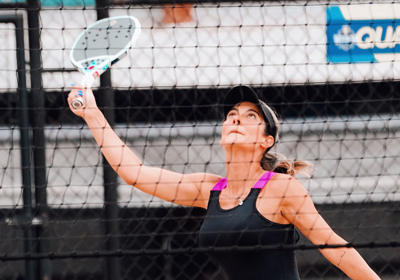 mulher se preparando para rebater bolinha no beach tennis