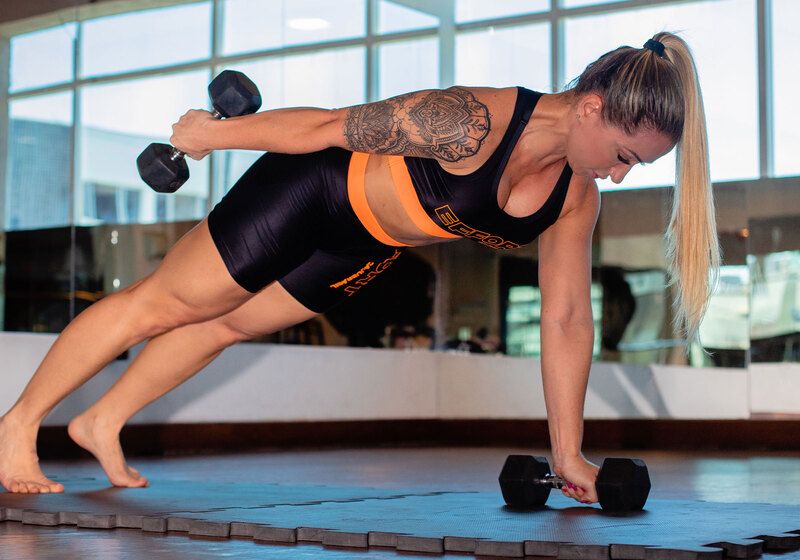 mulher fazendo exercicio com peso na academia