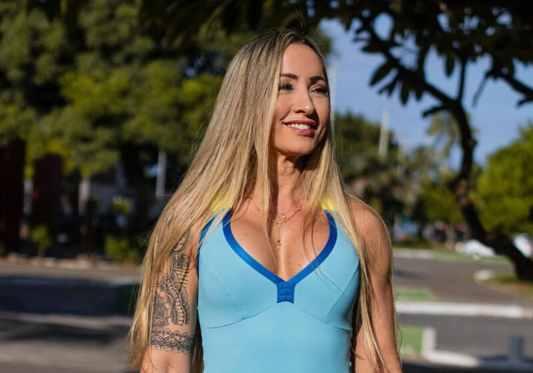 mulher fitness usando blusa azul e olhando lateralmente