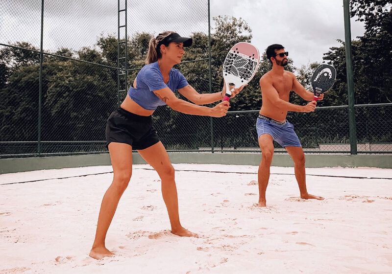 mulher e homem em quadra como parceiros jogando beach tennis