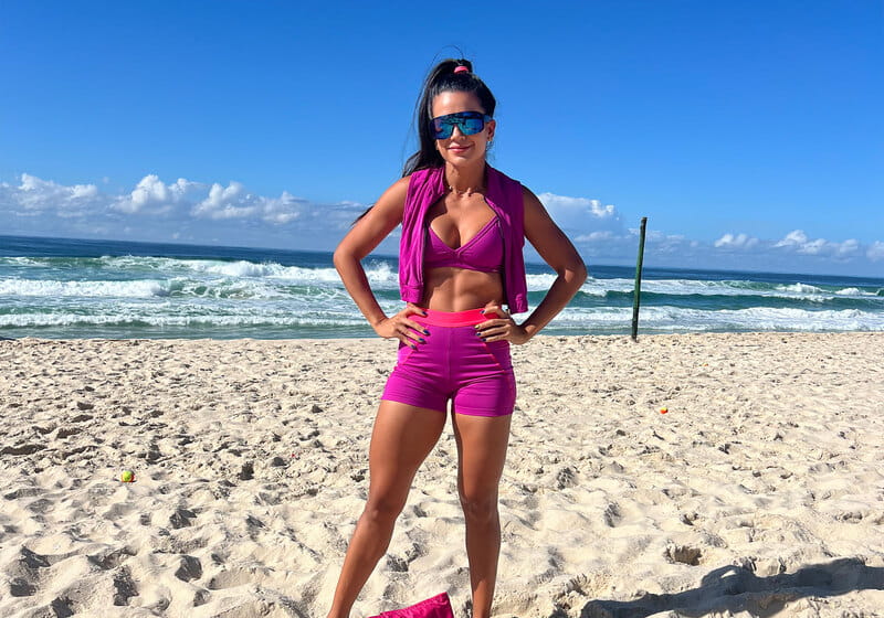 Mulher na praia com look fitness primavera-verão