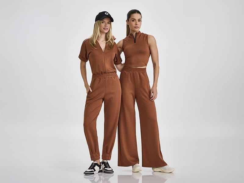 Duas mulheres vestindo roupas fashion em tom terroso.