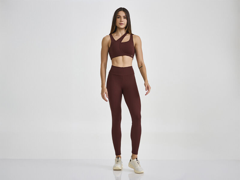 Modelo feminina vestindo roupas de treino marrom.