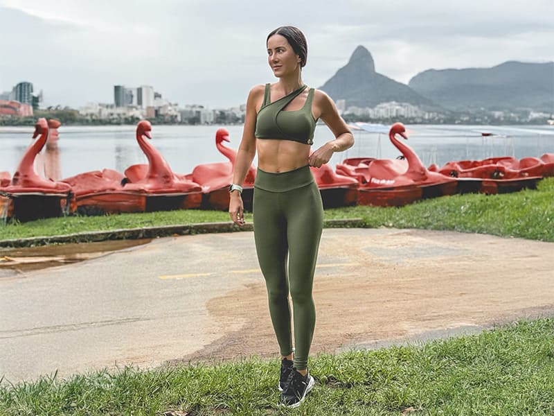 Mulher em roupas de treino em um parque perto da água