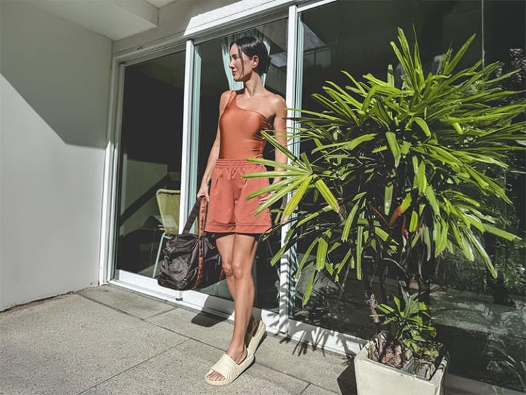 Mulher em trajes de verão ao lado de planta