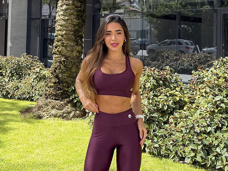 Mulher em academia com roupas de treino roxas
