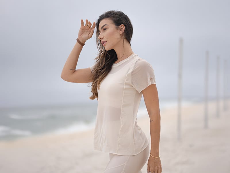 Mulher de camiseta clara na praia