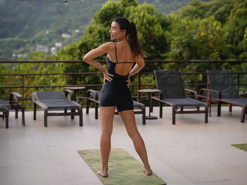 Mulher em posição de yoga ao ar livre